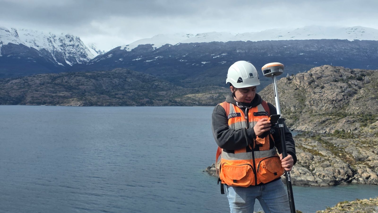 Profesional midiendo con GNSS frente al lago